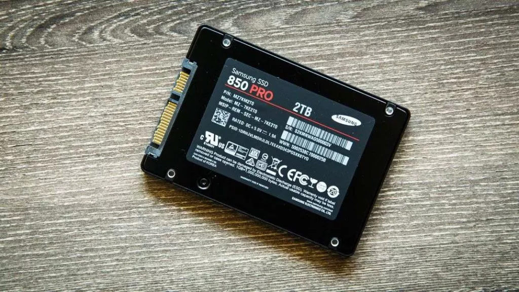 Laptop performance boost with SSD upgrade in PerthBlack Samsung 850 Pro SSD with a 2TB capacity lies on a wood-textured surface. Labels and specifications are visible, highlighting it as sleek and modern.