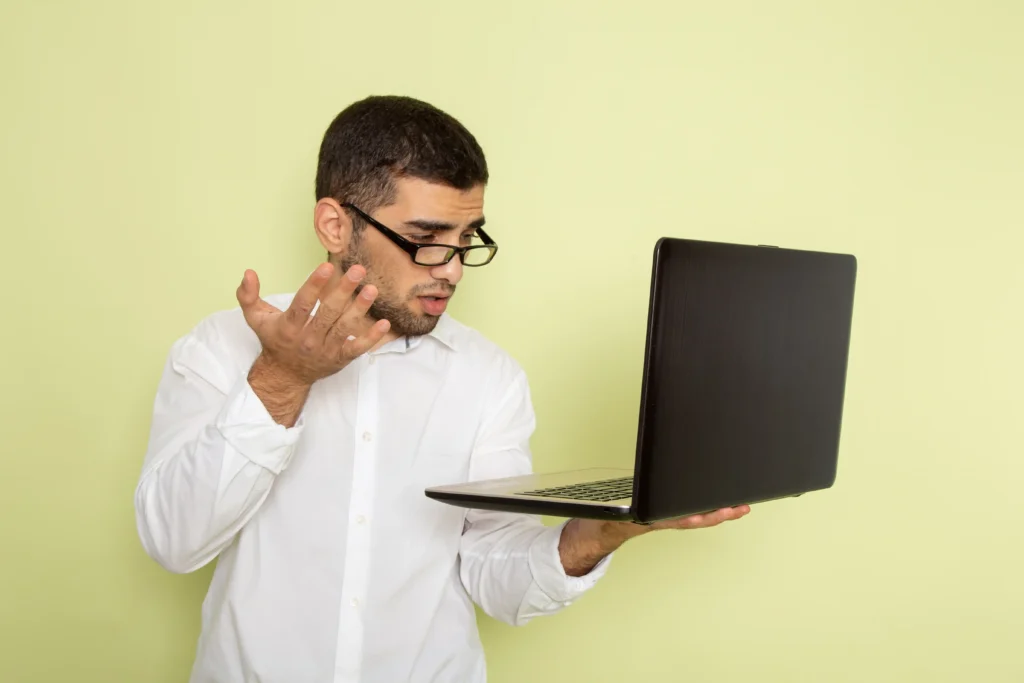 Concerned laptop user listening closely to their computer, illustrating a strange sound coming from a laptop and possible hardware issues.