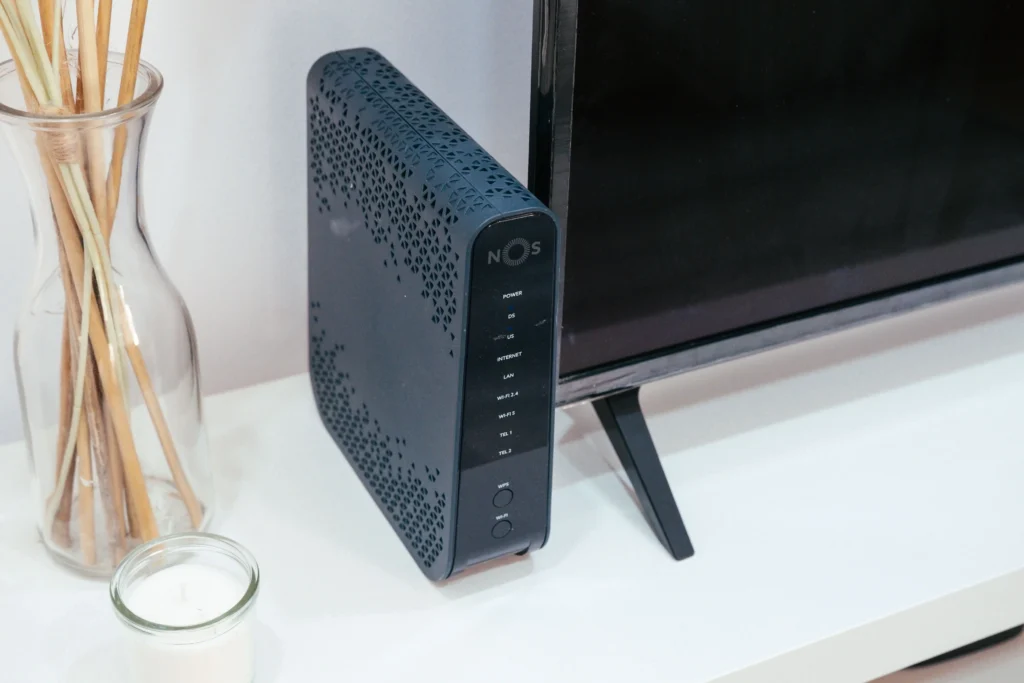 An NBN modem or router positioned beside a television, showing the equipment used to connect a home to an NBN internet service.