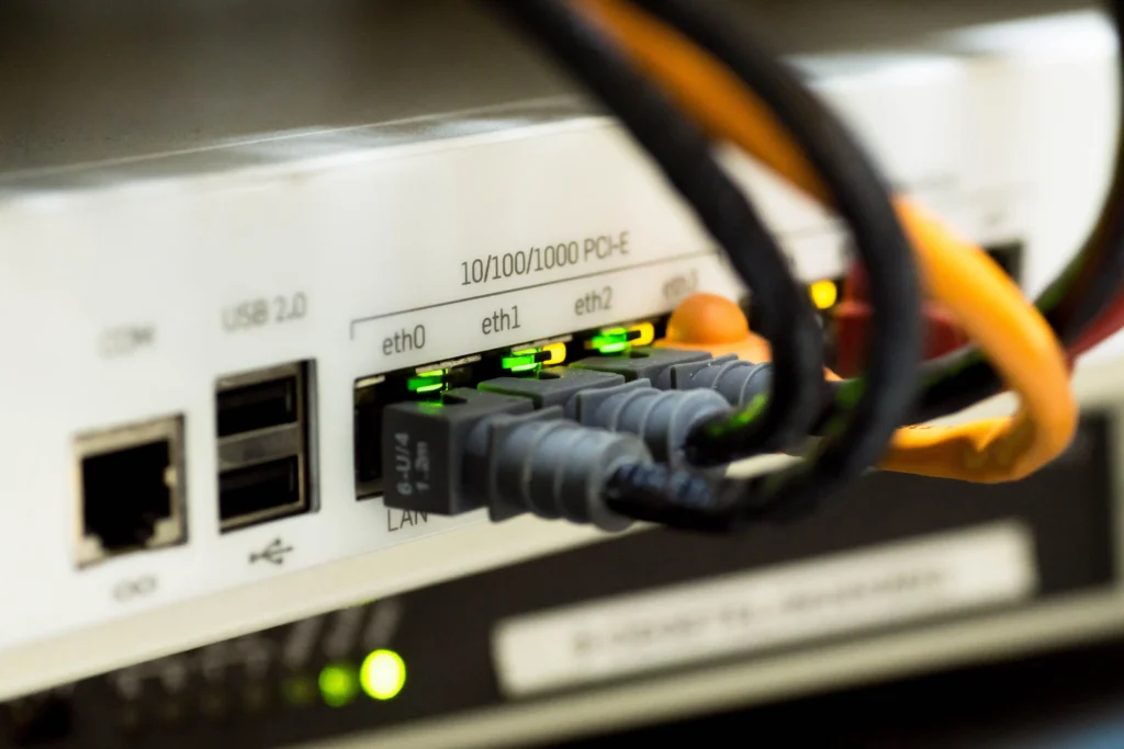 Close-up of Ethernet cables connected to a network device, with illuminated LAN ports showing an active wired internet connection.