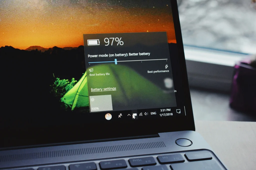 A laptop displaying Windows battery settings with a 97% battery level and power mode set to prioritize better battery life.
